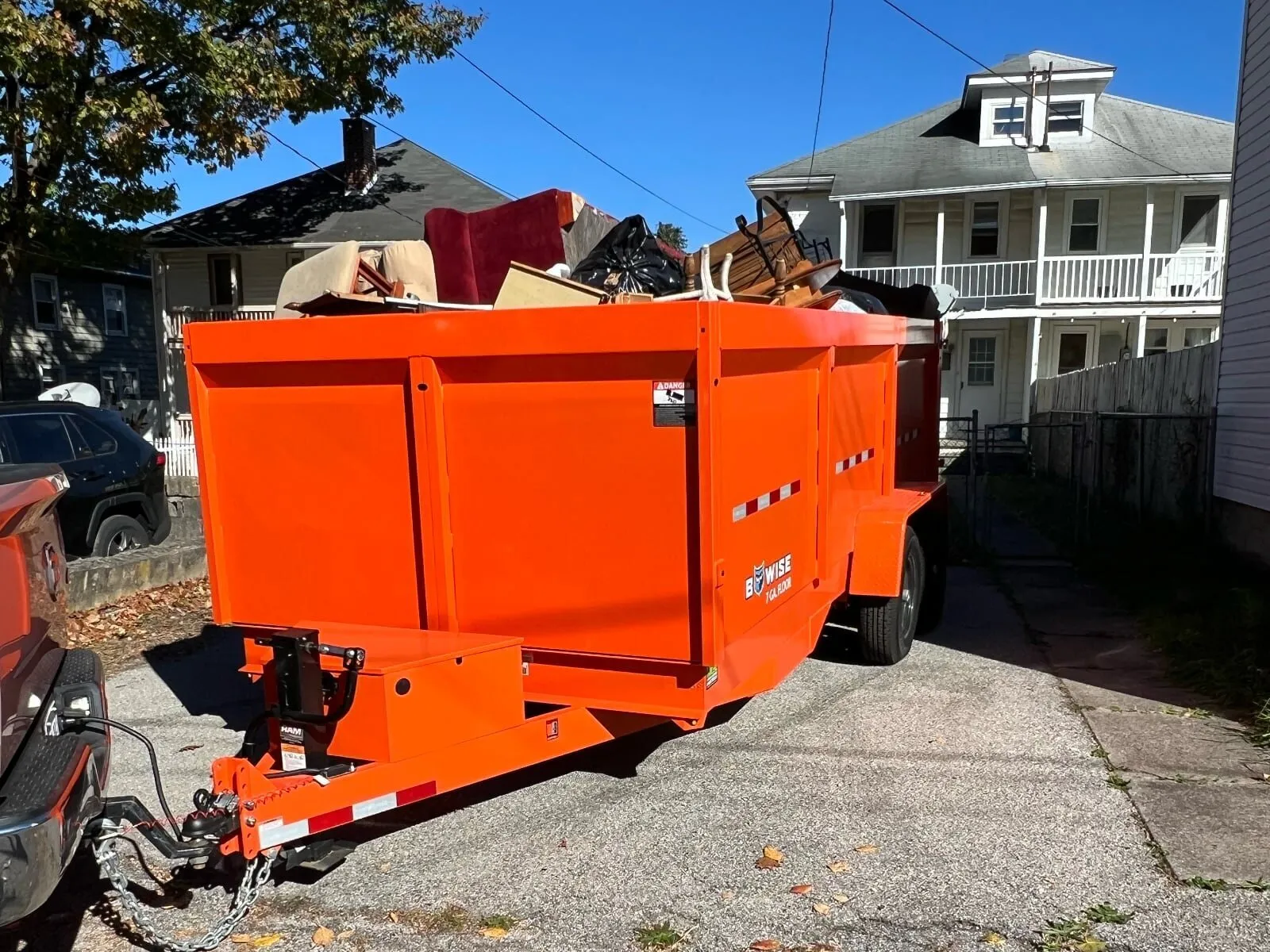 Loaded orange Kingdom Haulers dump-trailer dumpster in a York County driveway
